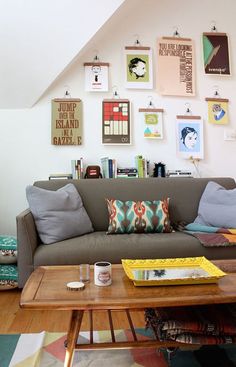 a living room filled with lots of furniture and pictures on the wall above it's coffee table