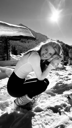 a woman kneeling in the snow with her legs crossed