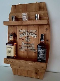 a wooden shelf with liquor bottles and glasses on it, next to a wall mounted bottle opener