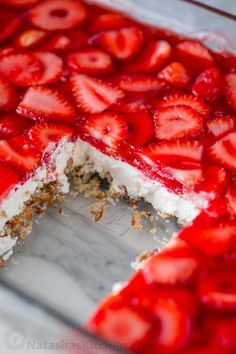 a cake with strawberries on it is cut in half and ready to be eaten