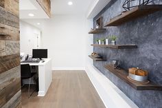 a home office with wooden shelves and shelving on the wall, along with a computer desk