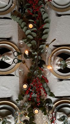 the table is decorated with candles and greenery