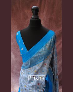 This grey saree features bandhani print on Pashmina silk, accented by a striking blue contrast border. Expertly crafted using the perfected hand block printing technique, the border of the saree narrates the timeless stories of rural villagers from centuries past. The saree is completed with elegant blue tassels. Blouse: Blue bandhani printed Pashmina silk [unstitched] Please note, slight color variations may occur due to lighting. please send us a message if you want blouse material separated Blue Jamawar Pre-draped Saree With Zari Weaving, Blue Tussar Silk Pre-draped Saree With Dupatta, Blue Pre-draped Banarasi Silk Saree With Dupatta, Blue Chanderi Dupatta With Printed Border, Blue Silk Pre-draped Saree For Festivals, Blue Art Silk Dupatta With Bandhani Print, Blue Silk Traditional Wear With Printed Border, Blue Tussar Silk Dupatta With Printed Border, Transitional Blue Saree With Pallu Detail