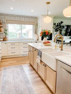 a kitchen with wooden cabinets and white counter tops, an area rug in front of the sink