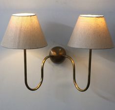 two lamps mounted on the wall next to each other with one light on it's side