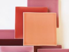 several different colored square plates stacked on top of each other, all one is orange and pink