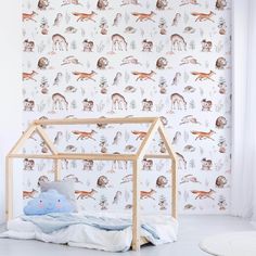 a baby's room with deer wallpaper and a wooden doll house