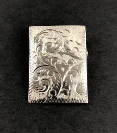 This is a lovely estate sterling silver rectangular domed pin brooch featuring an engraved floral, botanical, Art Nouveau design. It has a functional roll over catch. The pin is hallmarked STERLING and tests positive for sterling silver with the 18K acid solution (video of testing is available upon request, prior to purchase). A partial maker's mark is also visible.  Weight: 4.27 G Length: 1.23" (3.1 cm) Width: 0.89" (2.26 cm) Very good estate preowned condition (see photos, video). A tarnish-re Silver Engraved Heirloom Brooches, Silver Heirloom Engraved Brooches, Classic Engraved Brooches For Formal Occasions, Silver Engraved Brooches For Formal Occasions, Collectible Engraved Silver Brooch, Classic Silver Engraved Brooches, Classic Engraved Silver Brooches, Black Patch, Art Nouveau Design