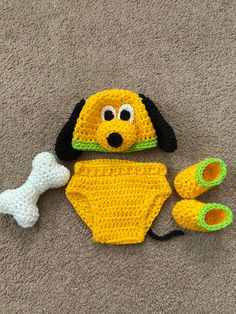 a crocheted dog hat, diaper and booties are laying on the floor