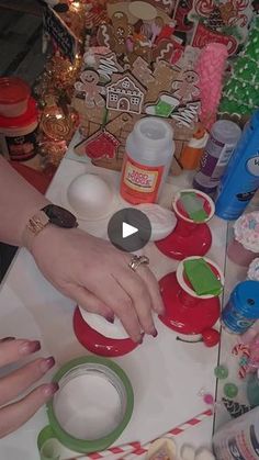 a person is decorating christmas cookies on a table