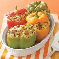 stuffed bell peppers in a white dish on an orange and white tablecloth