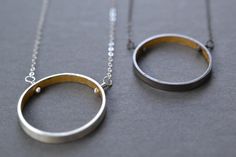 A simple circle with a secret inside.  A wide band of sterling silver has been formed into a circle and the inside coated with 23k yellow gold leaf.  Circle is 4 mm thick and the diameter of the circle is around 1 inch.  Securely attached to sterling silver curb chain with wired headpins.  Oxidized or bright finish available.  16 or 18 inch length.Gold leaf has been sealed with a clear varnish to protect the finish.Add the matching earrings to complete the look- https://www.etsy.com/listing/4677 Modern Circular Necklaces For Anniversary, Modern Hammered Round Necklace, Modern Open Circle Necklaces For Anniversary, Modern Open Circle Necklace For Anniversary, Minimalist Full Circle Jewelry For Anniversary, Modern Open Circle Jewelry For Anniversary, Modern Hammered Necklace With Round Pendant, Minimalist Silver Hoop Necklace, Modern Open Circle Necklace As A Gift