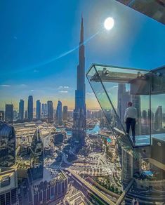 a man standing on top of a tall building looking out at the cityscape