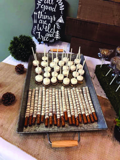 a tray filled with food on top of a table next to pine cones and candles