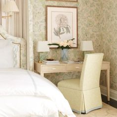 a bedroom with floral wallpaper and white bedding