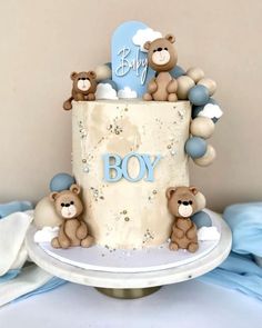 a baby cake with teddy bears on top and the word boy spelled out in blue