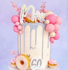 a birthday cake decorated with balloons and confetti