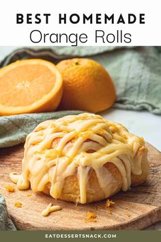 the best homemade orange rolls with icing on a cutting board next to sliced oranges