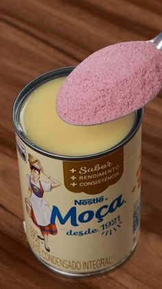 a wooden table with a can of moca and a pink sponge sticking out of it