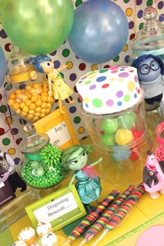 a table topped with lots of candy and balloons