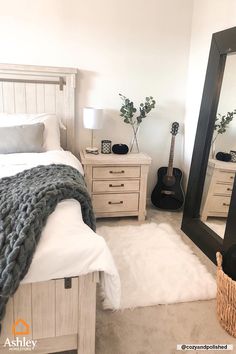 a bed room with a neatly made bed and a guitar