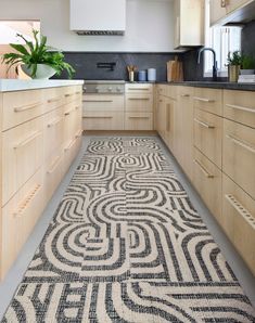 a kitchen with wooden cabinets and an area rug that looks like a maze in the floor