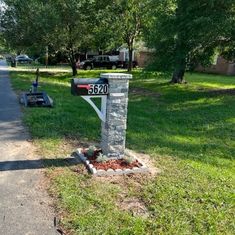 a mailbox sitting on the side of a road next to a tree and grass