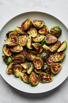 roasted brussel sprouts on a white plate, ready to be eaten