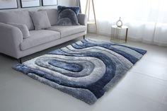 a living room with a gray couch and blue rug