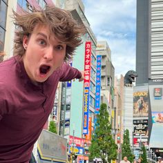 a young man making a surprised face in the city