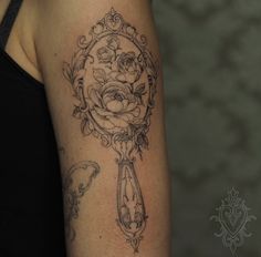 a black and white photo of a woman's arm with tattoos on it,