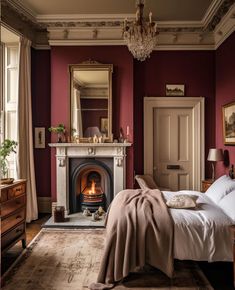 a bedroom with red walls and a fireplace