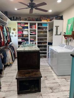 a laundry room with clothes hanging on the wall and a dryer in the closet