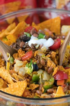 a glass bowl filled with taco salad and tortilla chips