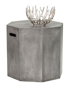 a concrete table with a metal plant on it's top and a hole in the middle