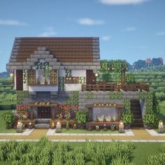 a house in the middle of a field with lots of plants and flowers around it