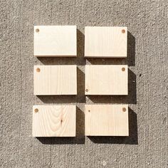 four pieces of wood sitting on top of a cement floor next to each other with holes in them