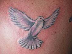 a white dove tattoo on the back of a man's shoulder and chest area