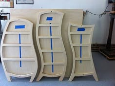 three bookshelves with blue tape on them are lined up against a wall in a room