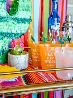 there are many different colored cups on the table