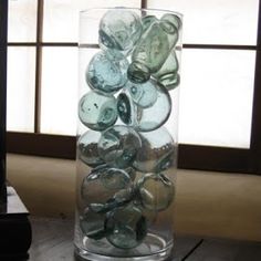 a vase filled with lots of glass pebbles