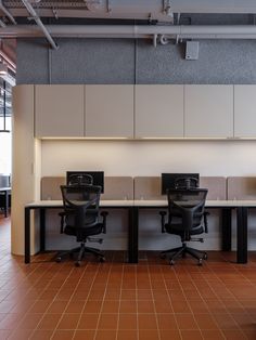 an office with two desks and chairs in it