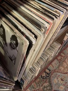 a pile of records sitting on top of a rug