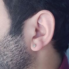 a close up of a man's ear with a diamond in the middle and behind it