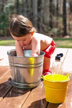 a small child is playing in a bucket