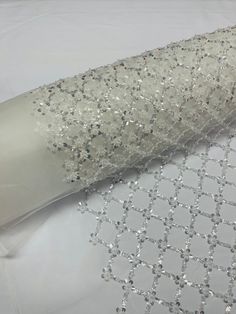 a roll of white sequins sitting on top of a cloth covered tablecloth