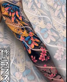 an arm tattoo with flowers and fish on it