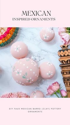 mexican inspired ornaments displayed on a table with pink flowers and vases in the background