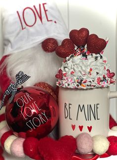 a coffee mug sitting on top of a table next to a christmas ornament