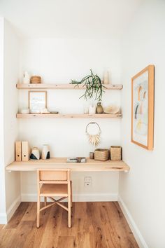 a wooden desk sitting in the corner of a room with shelves on each side and a potted plant next to it